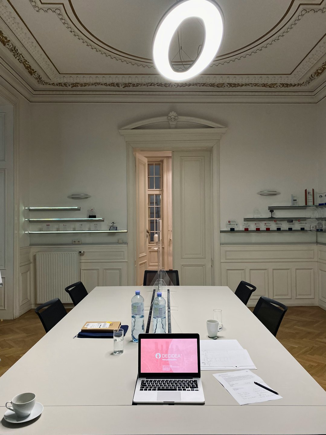 Empty conference room with a laptop open on a meeting table.